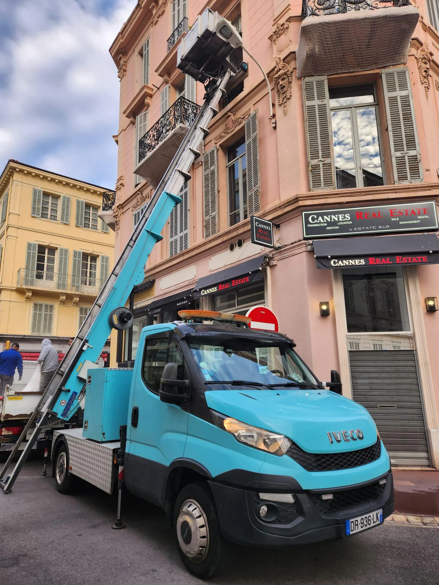 Camion monte-meuble stationné dans une rue urbaine, stabilisateurs sortis sur la chaussée