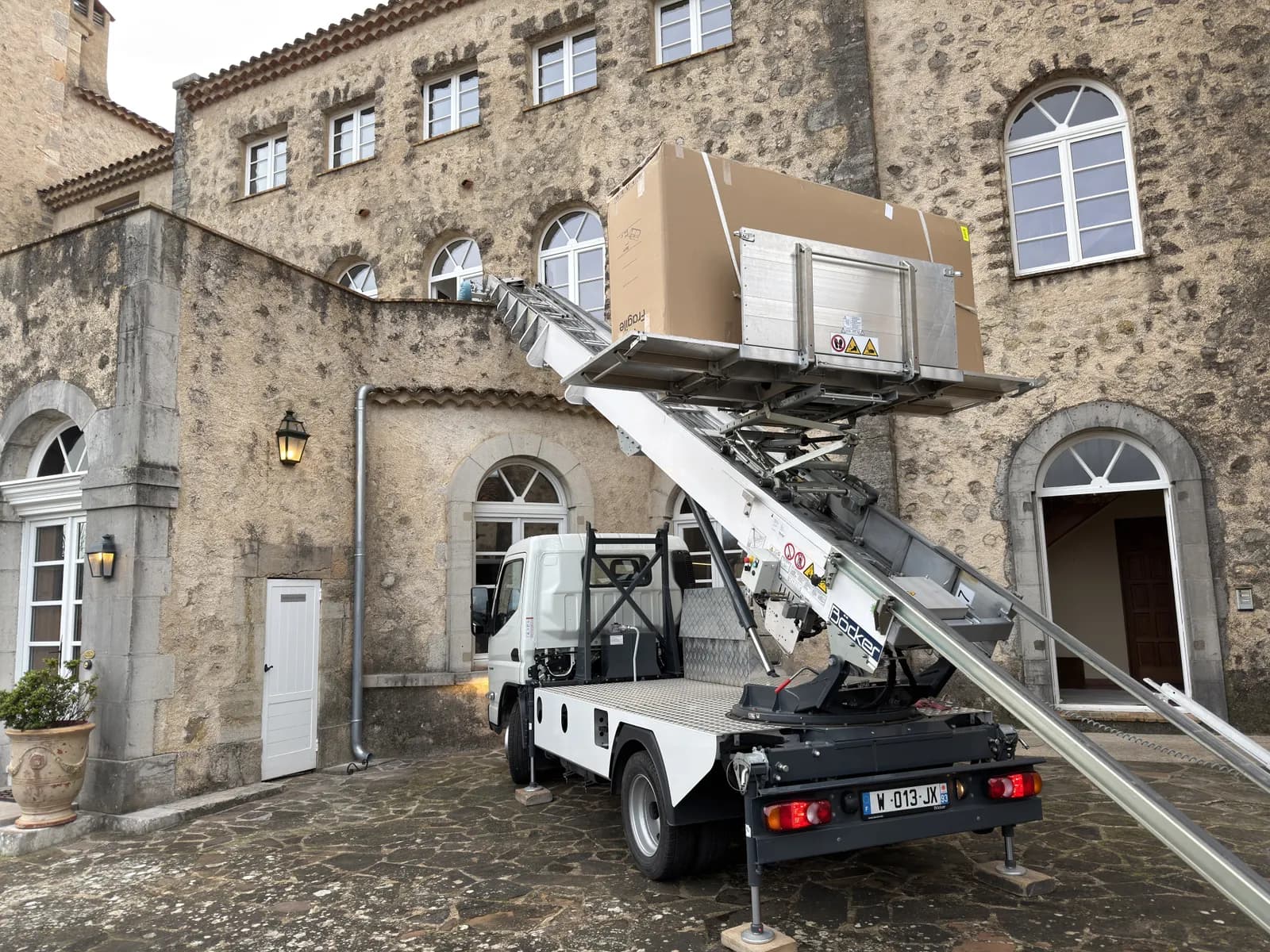 Bastide en pierre de plusieurs niveaux, façade sur laquelle une charge peut être levée par l'extérieur