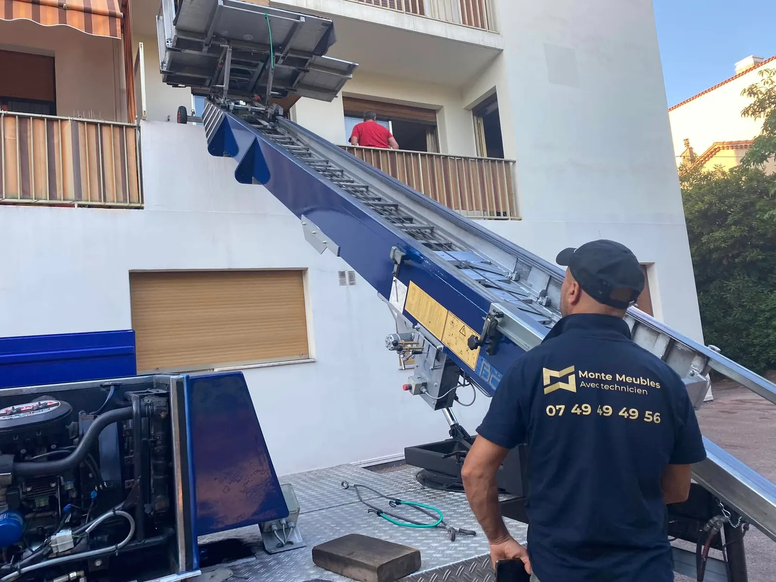 Technicien de levage au pied d'un monte-meuble, prêt à charger le plateau